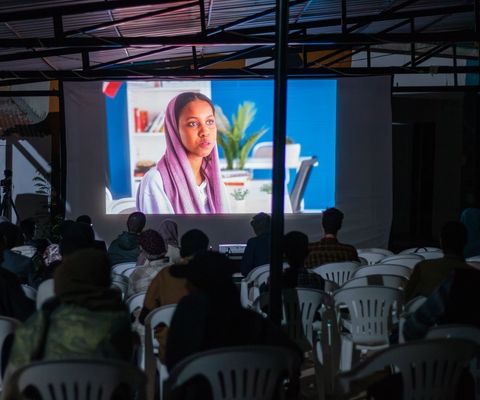 Audience watching a film on the big screen in the courtyard